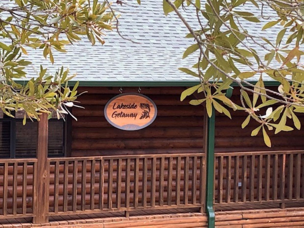A wooden building with a sign that reads "Lakeside Getaway."