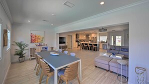 Un espacio habitable amplio con una mesa de comedor, sofá y una cocina al fondo.