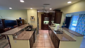 A kitchen with granite countertops, a central island, and a built-in oven. - A Tropical 2 Bedroom/2 Bath House w/ Pool and Dock (Osprey)