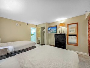 A hotel room with two beds, a dresser, a television, and a painting on the wall. - Oceanfront Retreat | Sand Dunes Twenty-Six Twenty-Six (Myrtle Beach)