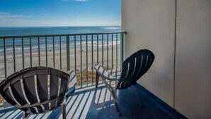 A balcony with a view of the beach and ocean, two chairs, and a wall-mounted light fixture. - Oceanfront Retreat | Sand Dunes Twenty-Six Twenty-Six (Myrtle Beach)