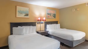A hotel room with two beds, a nightstand with lamps, two, and two paintings on the wall. - Sand Dunes 2626 (Myrtle Beach)
