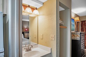 A bathroom with a white sink, a mirror, and a towel rack. - Ocean Air & Ease | SD Twenty-Six26 (Myrtle Beach)