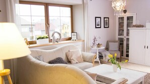 A living room with a sofa, coffee table, and a bookshelf. - Nice apartment for 6 guests with pool, WIFI, TV and patio (Zábreh)