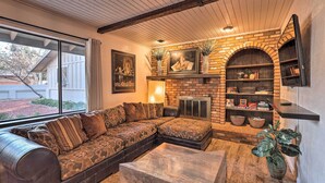 A cozy living room with a sectional sofa, a fireplace, and a TV mounted on the wall. - Hot Tub & Fire Pit: Sedona Oasis! (Sedona)