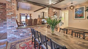 A dining area with a wooden table, chairs, and a brick fireplace. - Hot Tub & Fire Pit: Sedona Oasis! (Sedona)