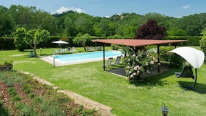 A backyard with a swimming pool, lounge chairs, a pergola, and a garden. - Wonderful private villa for 4 guests with pool, WIFI, TV and pets allowed (Terranuova Bracciolini)