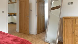 Una habitación con puertas de madera, un espejo grande y un armario de madera.