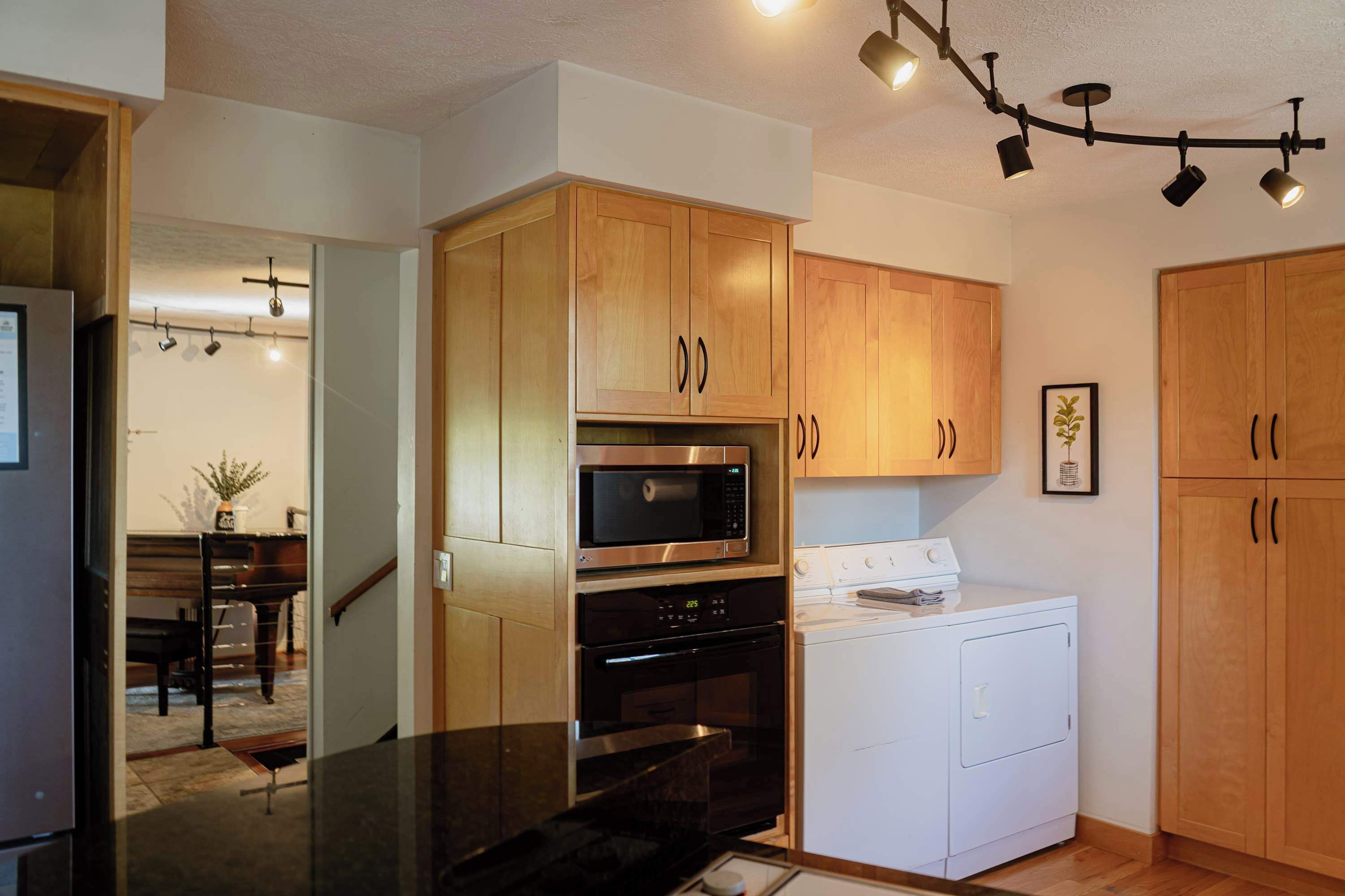 A modern kitchen with wooden cabinets, stainless steel appliances, and a built-in oven.