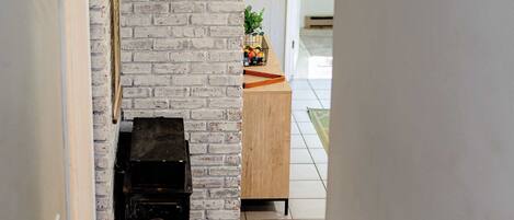 Una escalera que conduce a una habitación con una pared de ladrillo y una chimenea.