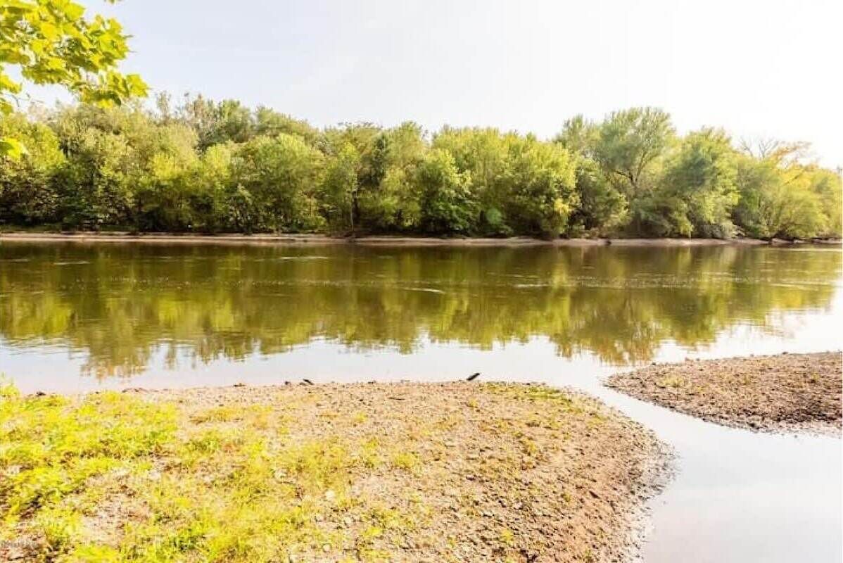 Un río tranquilo con árboles reflejados en el agua.
