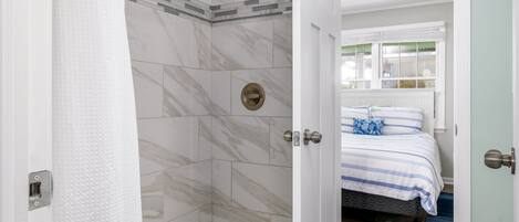 A bathroom with a shower, a toilet, and a sink.