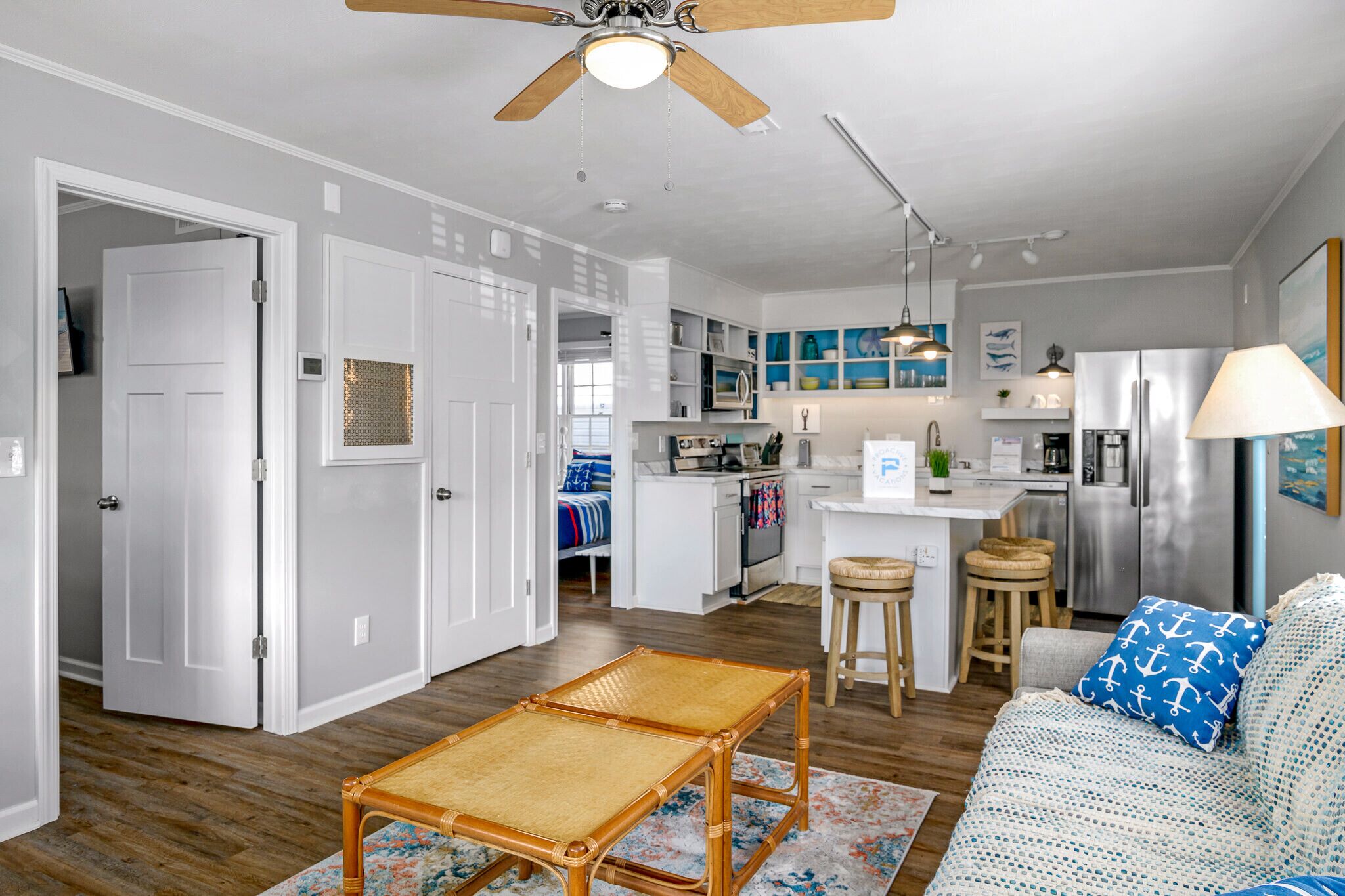 A modern kitchen with white cabinets, a central island, and a built-in microwave.