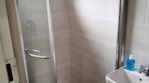 A bathroom with a shower, a sink, and a hand soap dispenser. - Room-immaculate and Beautiful Chalet - f (Kempton Park)