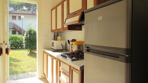 A kitchen with a refrigerator, stove, microwave, and a toaster. - Villa in Bibione Pineda by Beahost Rentals (San Michele al Tagliamento)