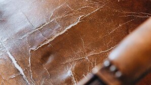 Een detail van een leren stoel met duidelijke slijtage.