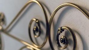 Une tête de lit en métal ornée de motifs décoratifs complexes.