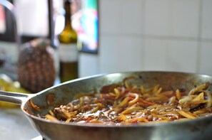 A close-up of a cooking pan with a dish containing meat and vegetables.
