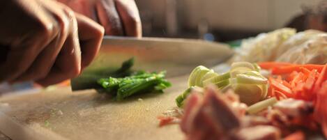 A person chopping vegetables on a cutting board.