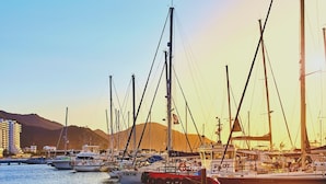 A marina with several boats docked, a clear sky, and a mountainous backdrop. - Hostal Hogar Buenaventura (Santa Marta)
