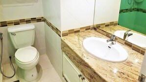A bathroom with a toilet, sink, and shower.