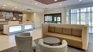 A lobby with a reception desk, a sofa, two armchairs, and a round table. - Holiday Inn Express & Suites Winston Salem Sw Clemmons by IHG (Clemmons)