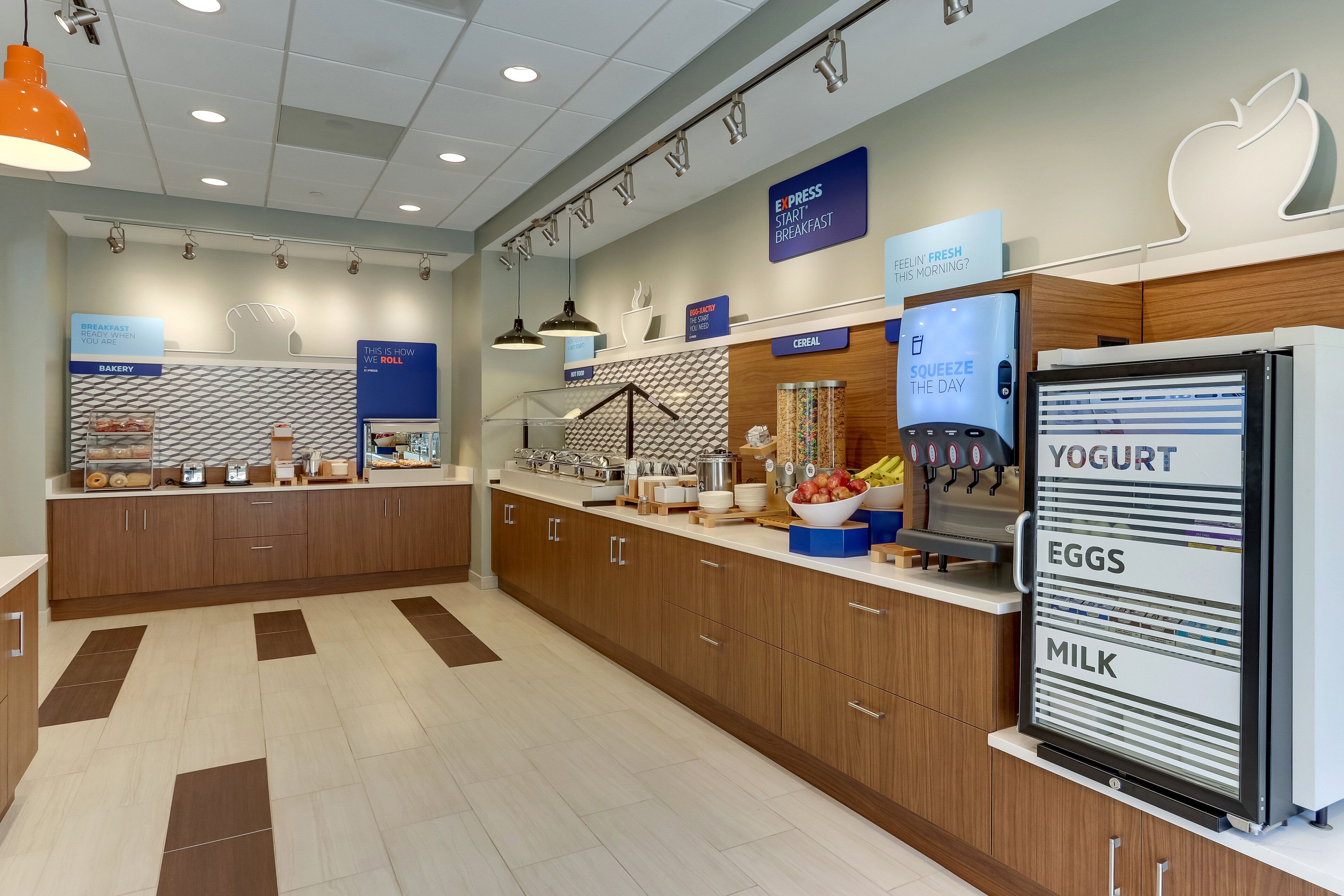 A modern breakfast area with a self-serve station, including options for yogurt, eggs, and milk.