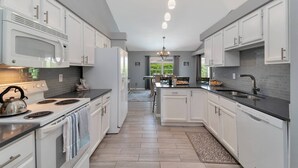 Una cocina moderna con armarios blancos, encimera negra y una isla central.