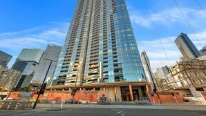 A tall, modern high-rise building with a glass facade, surrounded by other skyscrapers.