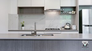 Una cocina moderna con encimera de mármol, electrodomésticos de acero inoxidable y estufa integrada.