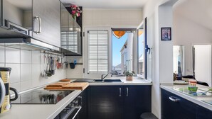 A modern kitchen with a sink, stove, and cabinets.