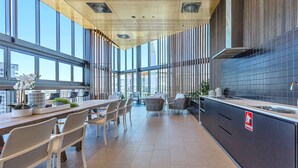 A modern kitchen with a large island, built-in appliances, and a view of the city. - KOZYGURU BRISBANE ONE 1Bed APT Parking (South Brisbane)