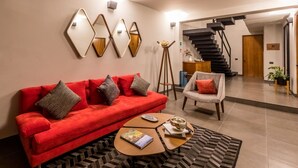 A modern living room with a red sofa, a coffee table, and a patterned rug. - Casa Olié (Oaxaca)