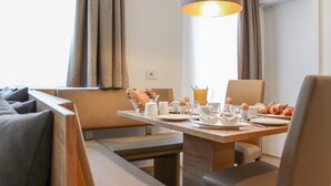 A breakfast setting with a table set for two, including croissants, eggs, and coffee. - Luxury Apart. mit 2 Schlafzimmern Terrasse (Antholz Mittertal)