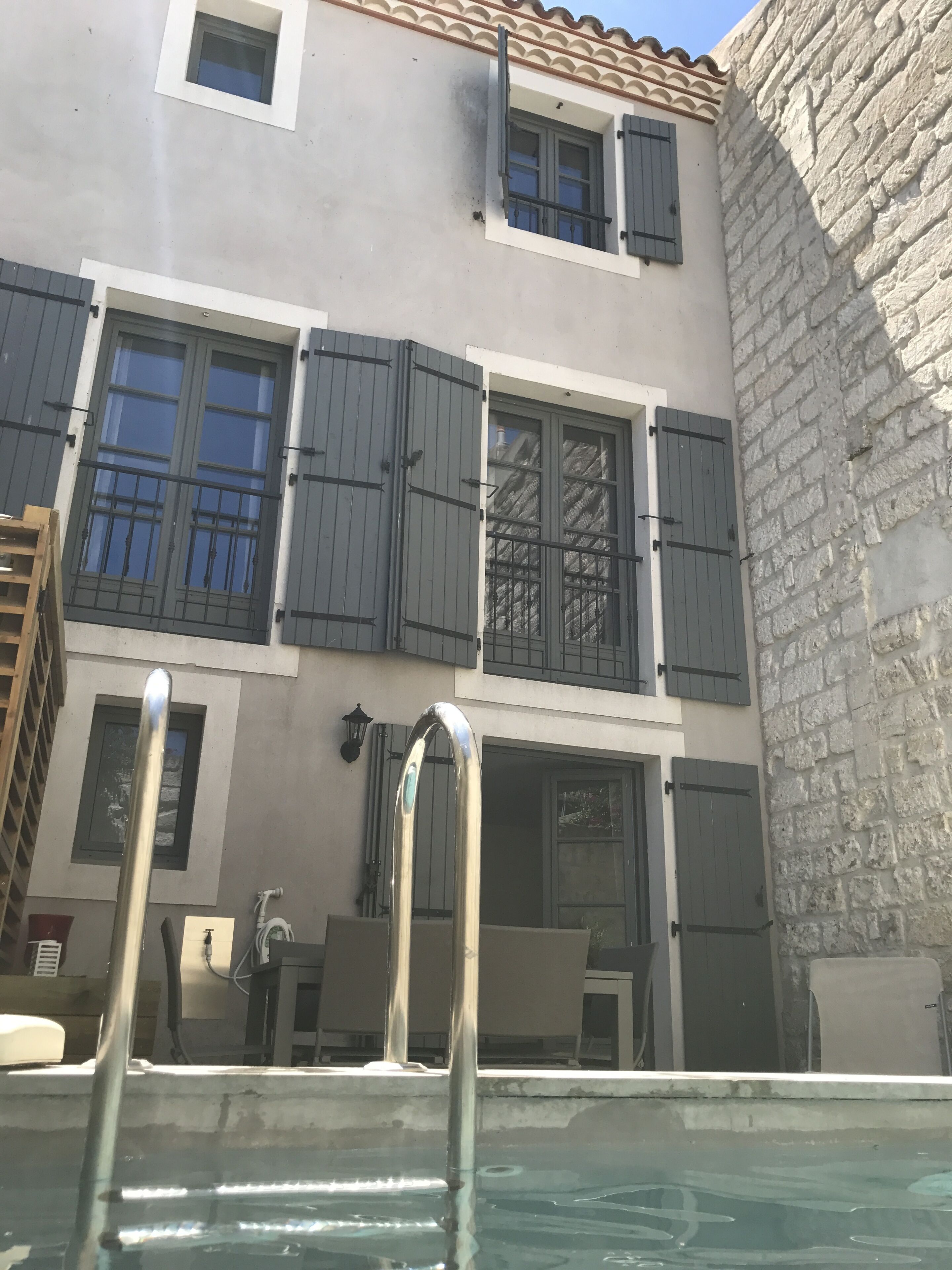 Ein Gebäude mit Pool, mit einer Treppe, die zu einem Balkon mit Blick auf den Pool führt.