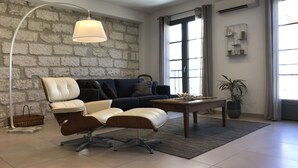 A modern living room with a leather sofa, a coffee table, and a floor lamp. - HOUSE WITH PATIO & POOL IN THE HEART OF THE RAMPARTS! (Aigues-Mortes)