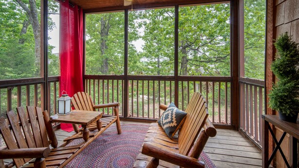 A wooden deck with a ceiling fan, wooden chairs, a table, and a potted plant. - Inviting, Equestrian-Themed Cabin in the Very Heart of Branson! (Branson)