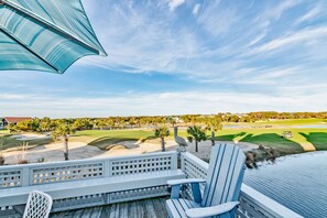 A deck with a view of a golf course, including sand bunkers and a pond. - Howards Haven (Bald Head Island)