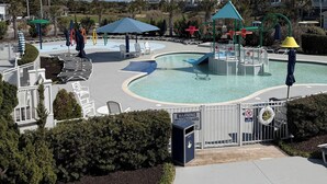 A swimming pool with a lifeguard station, lounge chairs, and umbrellas. - Howards Haven (Bald Head Island)