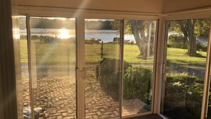 A room with a sliding glass door leading to a patio with a brick pathway and a view of a lake. - Majestic House on 23 acres with 5k feet of lakefront  (Fairfax)