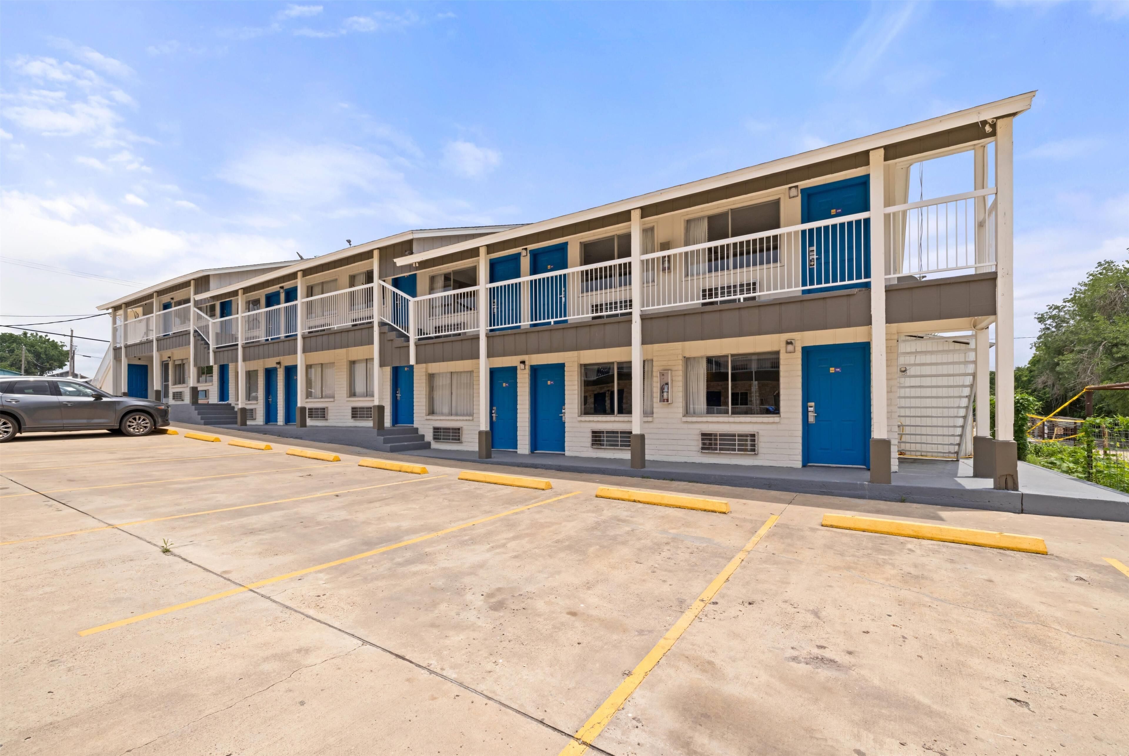 A multi-story motel with a parking lot.