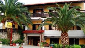 A building with a sign for 'Pavíkas Apartments' and a red-roofed entrance. - Finikas Apartments Polichrono (Kassandra)