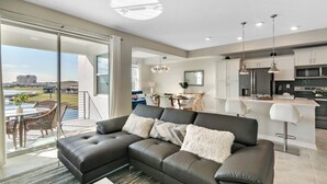 A modern living room with a sectional sofa, a dining area, and a kitchen. - 2 Bedrooms / 2 Bathrooms / Storey Lake (3131-303 PC) (Kissimmee)