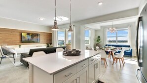A modern kitchen with a central island, pendant lighting, and a dining area with a view. - 2 Bedrooms / 2 Bathrooms / Storey Lake (3131-303 PC) (Kissimmee)