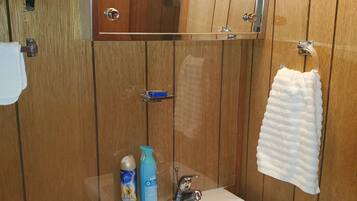 Tina con regadera, toallas, jabón, papel de baño