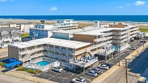 A multi-story hotel with a swimming pool, parking, and a view of the ocean. - Beachfront  top flr 1 br condo at Summer Sands (Wildwood)
