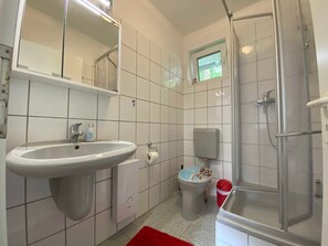 Un baño con lavamanos, inodoro y ducha.