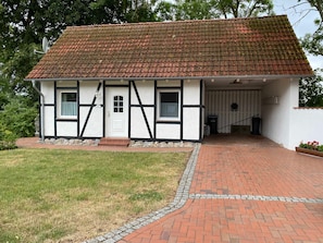 A traditional half-timbered house with a tiled roof, a front door, and a small porch area. - Ohlendorf Haus Ostseefischer - Haus Ostseefischer (Insel Poel)