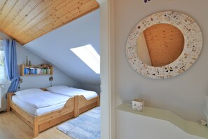 Et soveværelse med en træseng, ovenlys, en reol og en mosaikvæg.