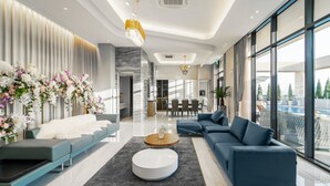 A modern living room with a sofa, a coffee table, and a dining area in the background. - Jeonju The May Hotel (Jeonju)